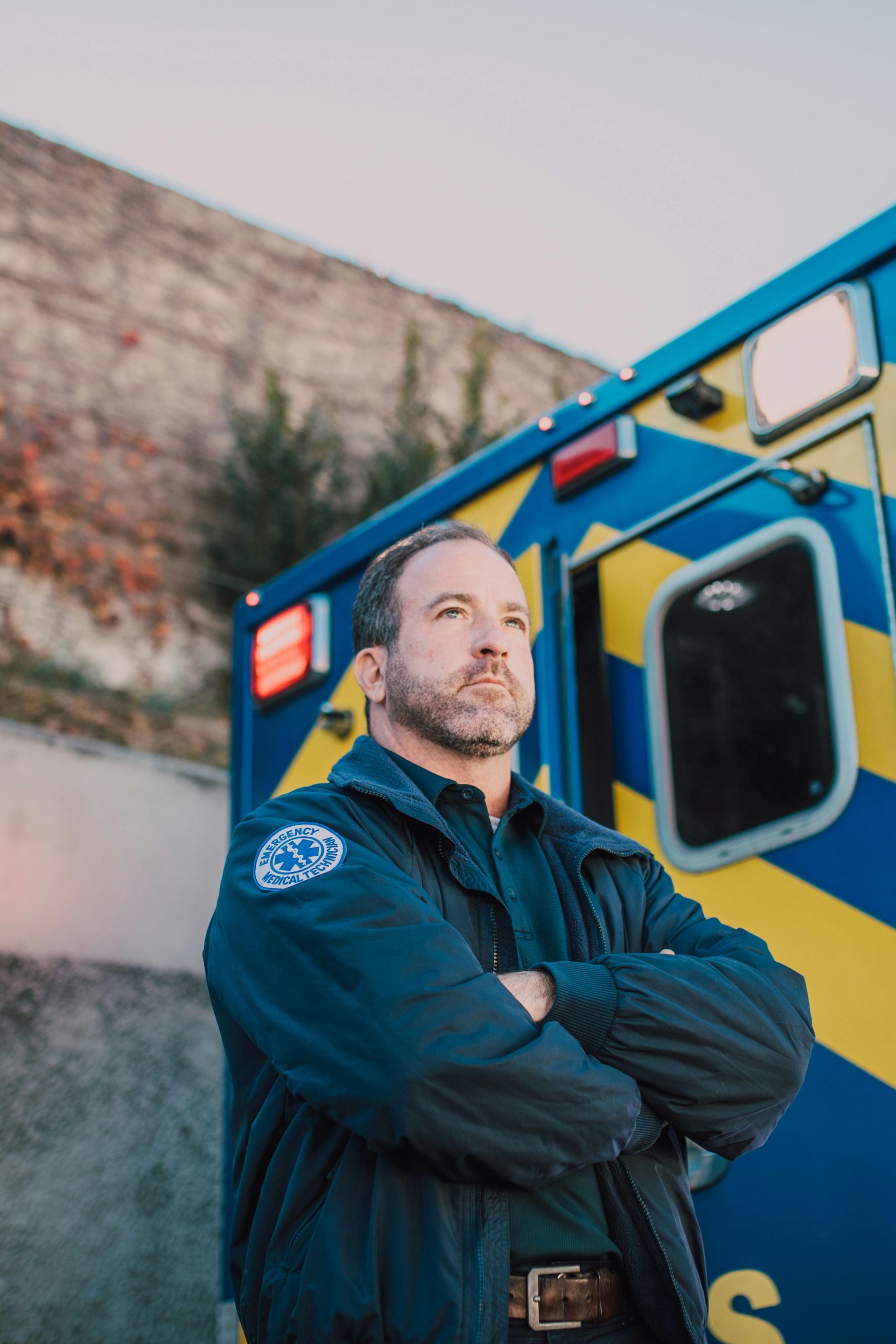 A paramedic confidently stands beside an ambulance, ready for action.